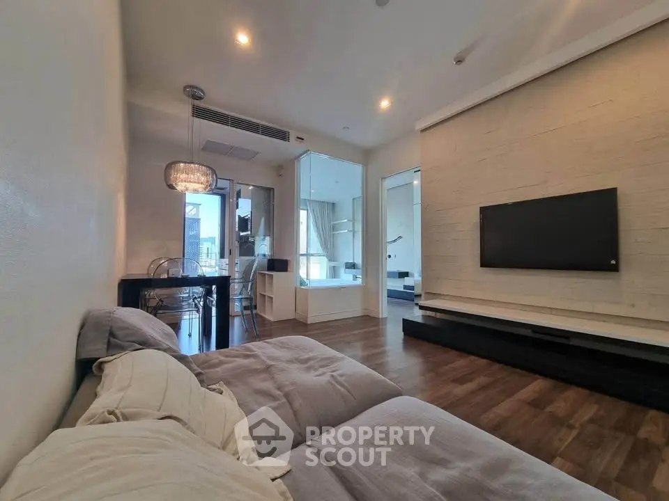 Modern living room with stylish decor and open layout, featuring a cozy sofa and wall-mounted TV.