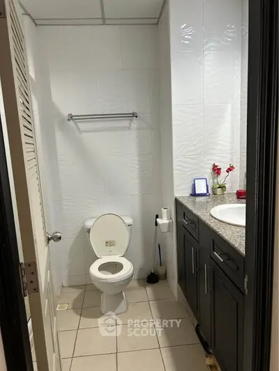Modern bathroom with sleek cabinetry and tiled walls, perfect for a contemporary home.