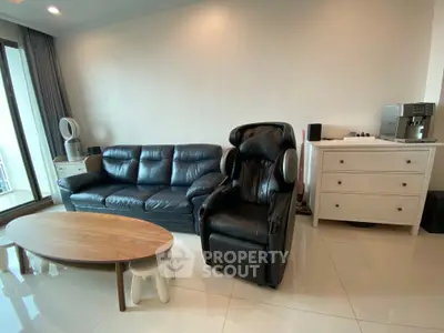 Modern living room with leather sofa, massage chair, and coffee table in a bright, spacious setting.