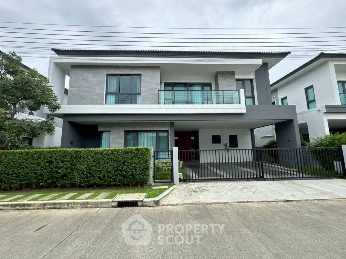 Modern two-story house with sleek design and spacious driveway in a suburban neighborhood.