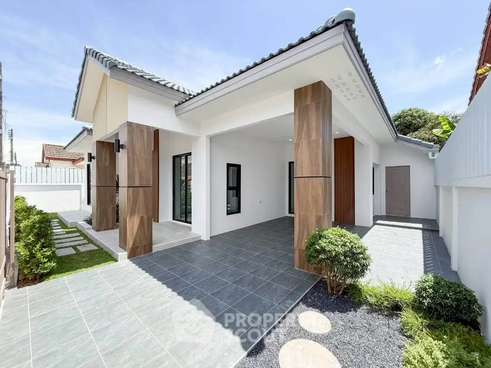 Modern single-story house with spacious driveway and elegant exterior design.