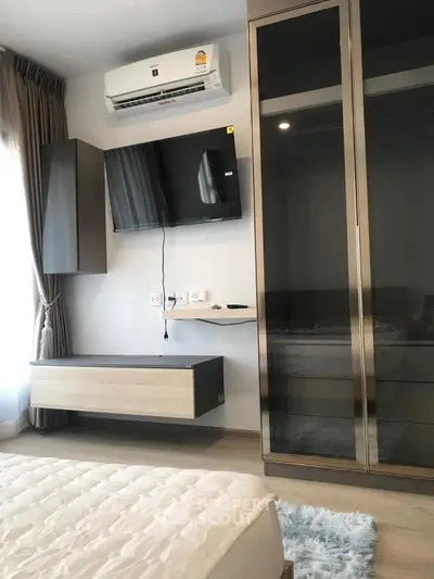 Modern bedroom with wall-mounted TV and sleek wardrobe design