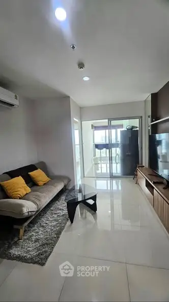Modern living room with sleek furniture and large windows offering natural light.