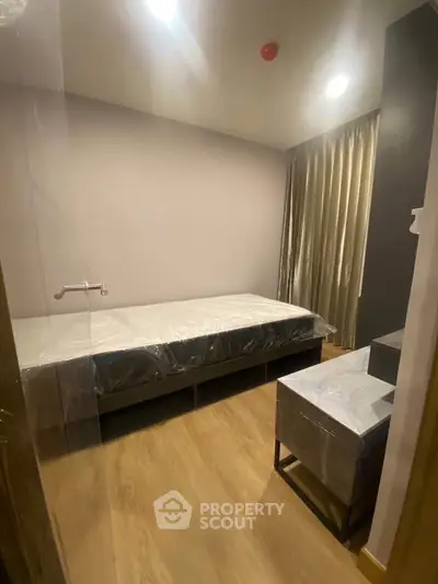Cozy bedroom with modern furnishings and wooden flooring, perfect for a minimalist lifestyle.