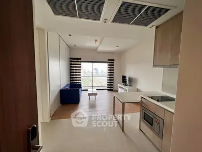 Modern open-layout living room with city view, featuring sleek kitchen and cozy seating area.