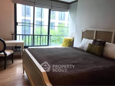 Cozy bedroom with large window and stylish decor in modern apartment