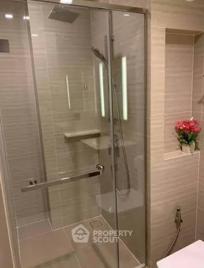 Modern bathroom with glass shower enclosure and elegant tile design