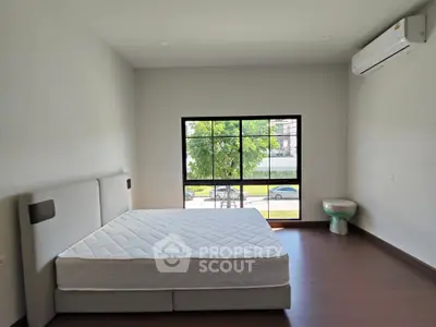 Spacious bedroom with large window and modern air conditioning unit.