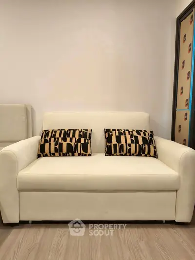 Modern living room with stylish white sofa and patterned cushions