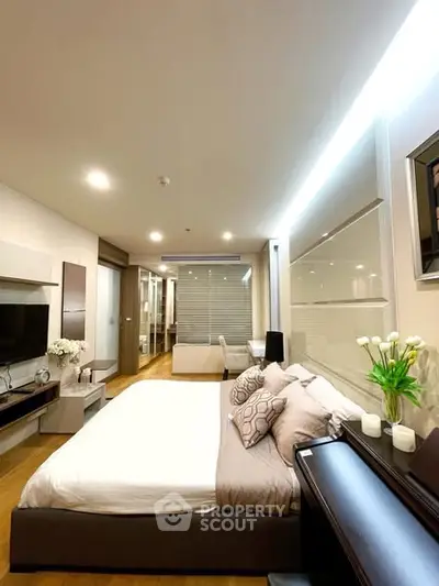 Modern bedroom with stylish decor and ambient lighting in a contemporary apartment.