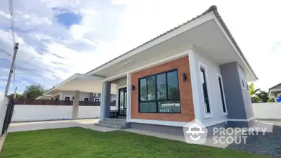 Modern single-story house with large windows and spacious yard