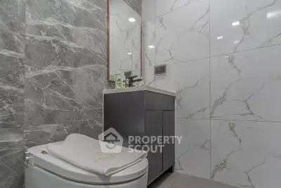 Modern bathroom with marble tiles and sleek vanity unit