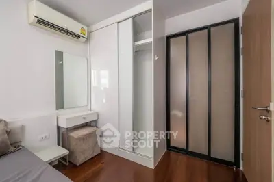 Modern bedroom with sleek closet and air conditioning in a stylish apartment.