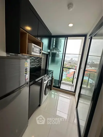 Modern kitchen with sleek appliances and city view from balcony