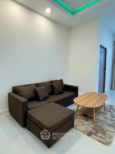 Modern living room with stylish sofa and wooden coffee table on a plush rug, perfect for cozy relaxation.