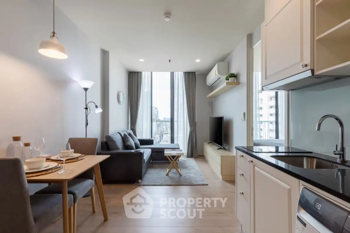Modern open-plan living room and kitchen with city view, stylish furniture, and natural light.
