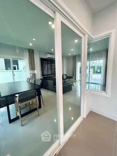 Modern living room with glass sliding doors and elegant dining area