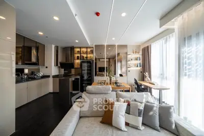Modern open-layout living room with sleek kitchen and dining area, featuring stylish decor and ample natural light.