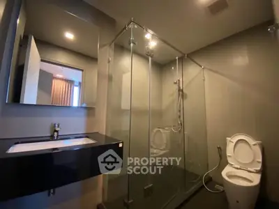 Modern bathroom with glass shower and sleek fixtures in a contemporary apartment.