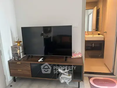 Modern living room with sleek TV stand and adjacent bathroom view