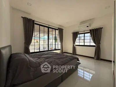Spacious bedroom with large windows and modern decor