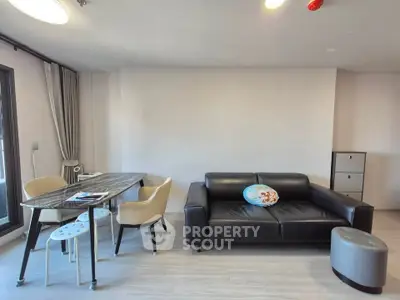 Modern living room with sleek black sofa and stylish dining area