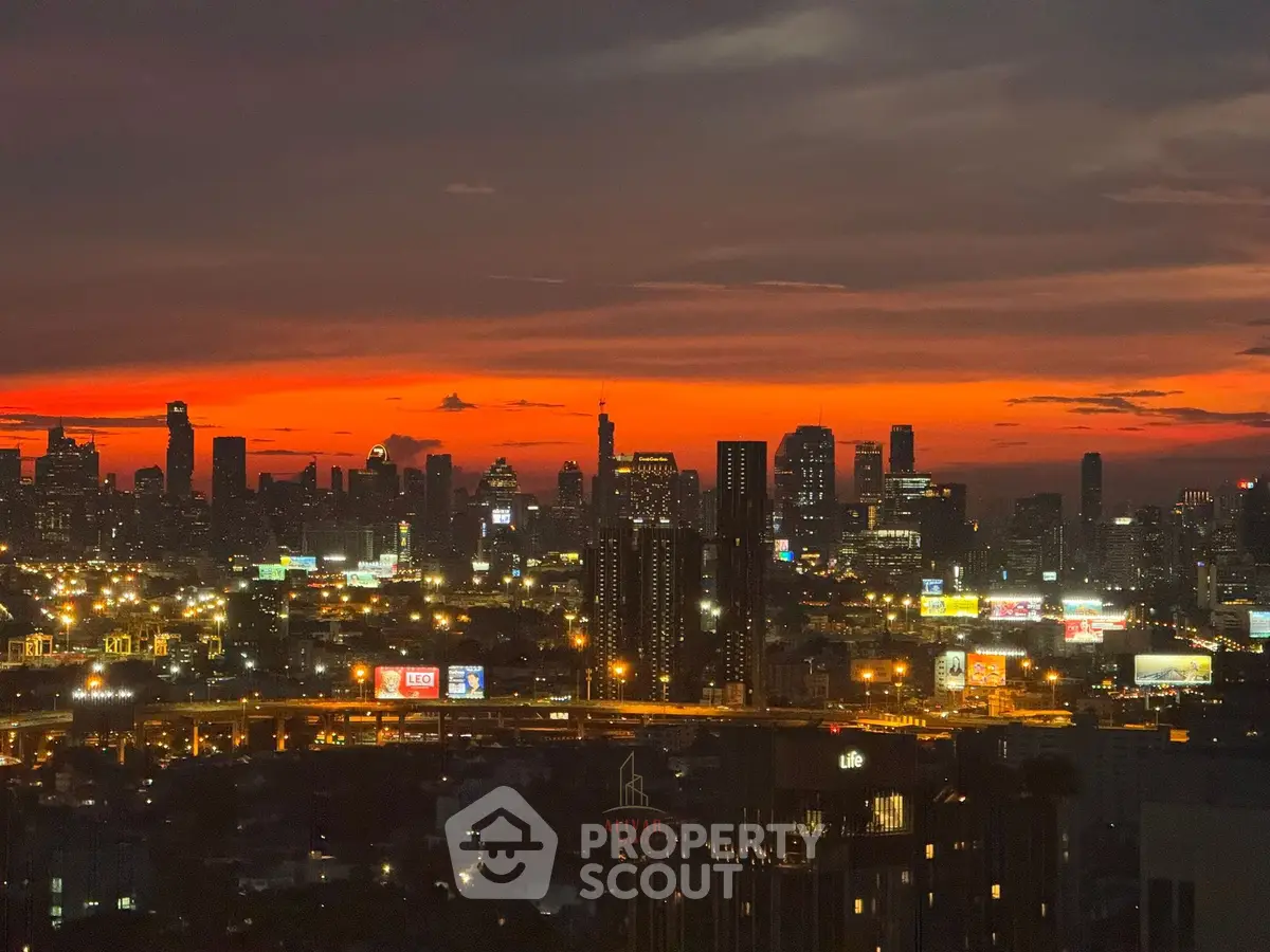 Stunning city skyline view at sunset with vibrant orange sky.