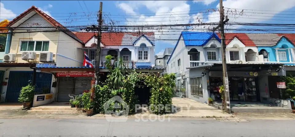 Charming row of colorful townhouses with unique architectural details and lush greenery in a vibrant neighborhood.