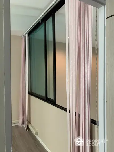 Modern hallway with floor-to-ceiling windows and elegant pink curtains