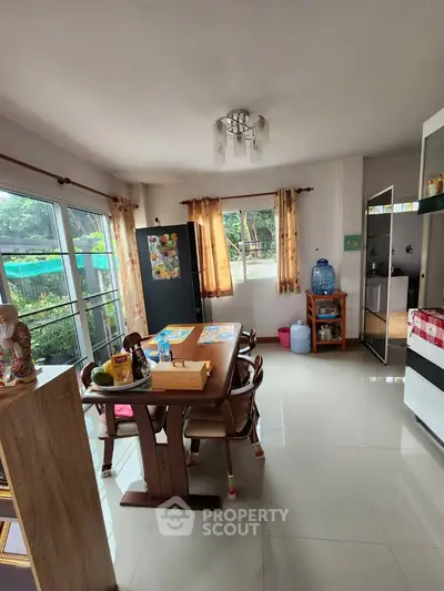 Spacious kitchen with dining area and large windows offering natural light.