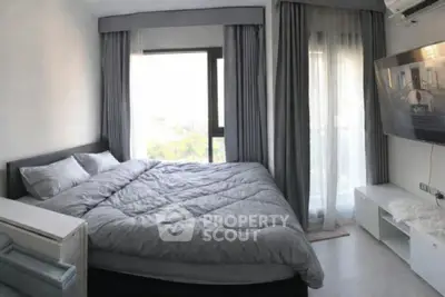 Cozy bedroom with large window and modern decor, featuring a comfortable bed and stylish curtains.