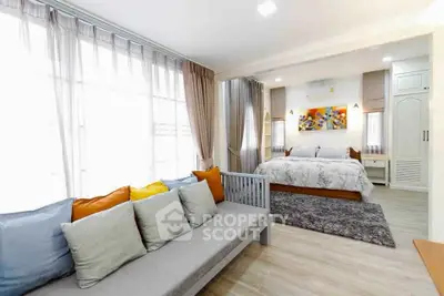 Spacious modern bedroom with cozy seating area and stylish decor