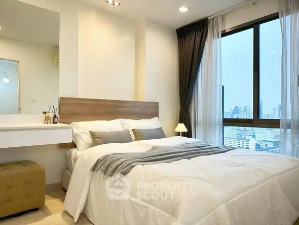 Modern bedroom with city view, featuring cozy bed and stylish decor in a high-rise apartment.