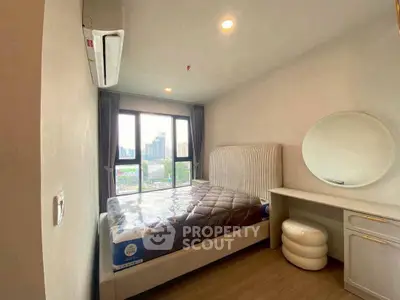 Modern bedroom with city view, featuring a stylish bed and elegant vanity.