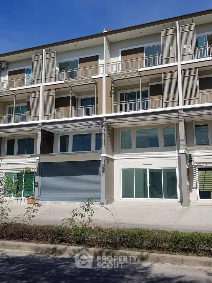 Modern multi-story building with balconies and large windows, ideal for urban living.