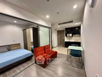 Modern studio apartment with open layout, featuring a cozy living area and compact kitchen.