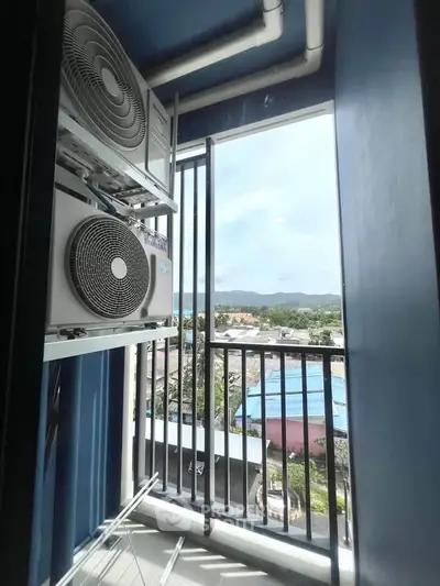 Compact balcony with air conditioning units and scenic view of the cityscape.