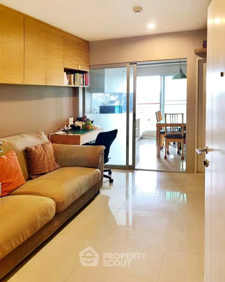 Modern living room with cozy sofa and study area leading to dining space