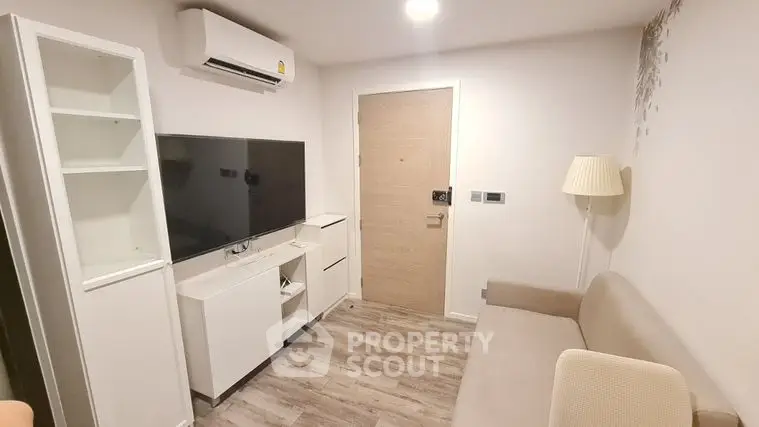 Cozy and modern living room with sleek white entertainment unit, comfortable beige sofa, and elegant wood flooring.