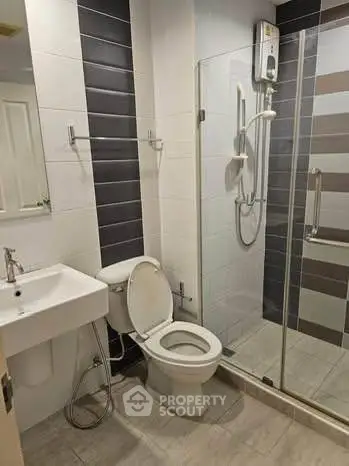Modern bathroom with glass shower and sleek fixtures in contemporary apartment.