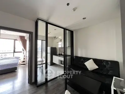 Modern apartment with open layout, featuring a sleek kitchen and cozy living area with abundant natural light.