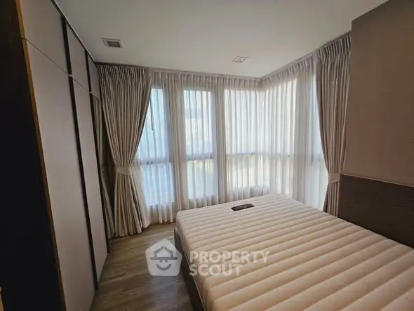 Modern bedroom with large windows and elegant curtains