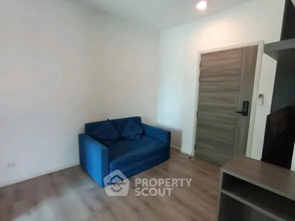 Cozy living room with blue sofa and modern wooden flooring