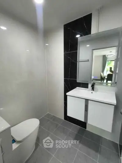 Modern bathroom with sleek fixtures and stylish black accent wall