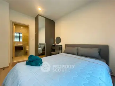 Cozy bedroom with ensuite bathroom and modern decor in a stylish apartment.