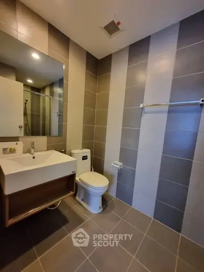Modern bathroom with sleek tiles and contemporary fixtures in a stylish real estate property.