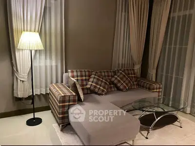 Cozy living room with stylish plaid sofa and elegant floor lamp, perfect for relaxation.