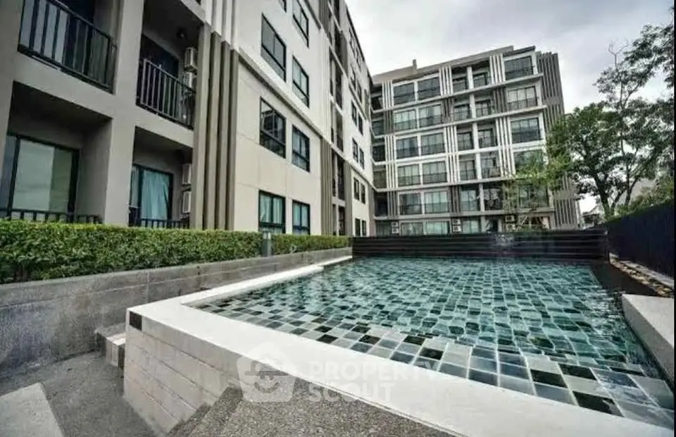 Modern apartment complex with stylish pool and lush greenery