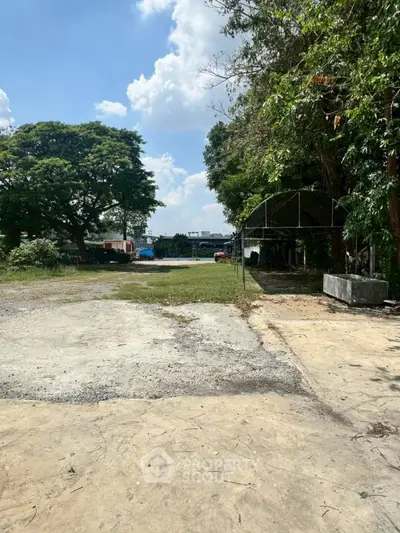 Expansive outdoor plot with lush greenery and clear skies, ideal for development opportunities.