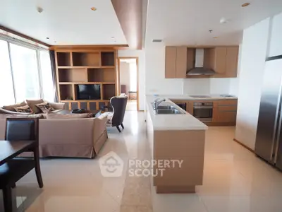 Modern open-layout living room and kitchen with sleek design and natural light.